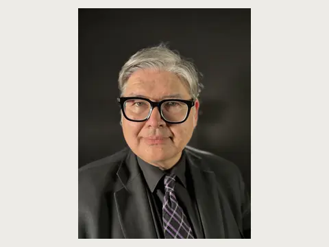 Close portrait of Herbert Midgley in a black suit and glasses.