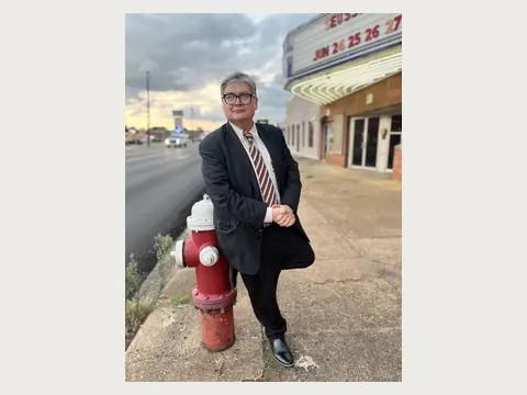 Herbert Midgley standing near a historic theater in East Texas.