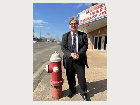 Herbert Midgley standing beside a fire hydrant near a historic theater.