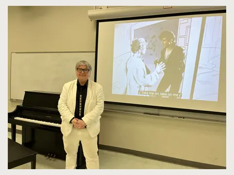 Herbert Midgley teaching in front of a projection screen.