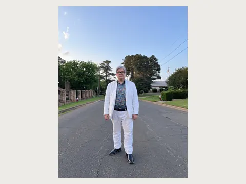 Herbert Midgley preparing to teach in a white suit.