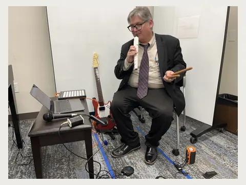 Herbert Midgley demonstrating guitar and music technology.