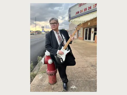 Herbert Midgley holding an electric guitar in East Texas.