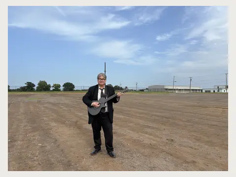 Herbert Midgley standing on a large open production location.