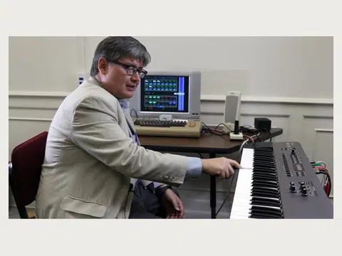 A younger Herbert Midgley working with a digital music keyboard.