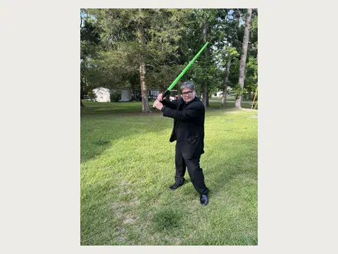 Herbert Midgley posing with a green lightsaber.