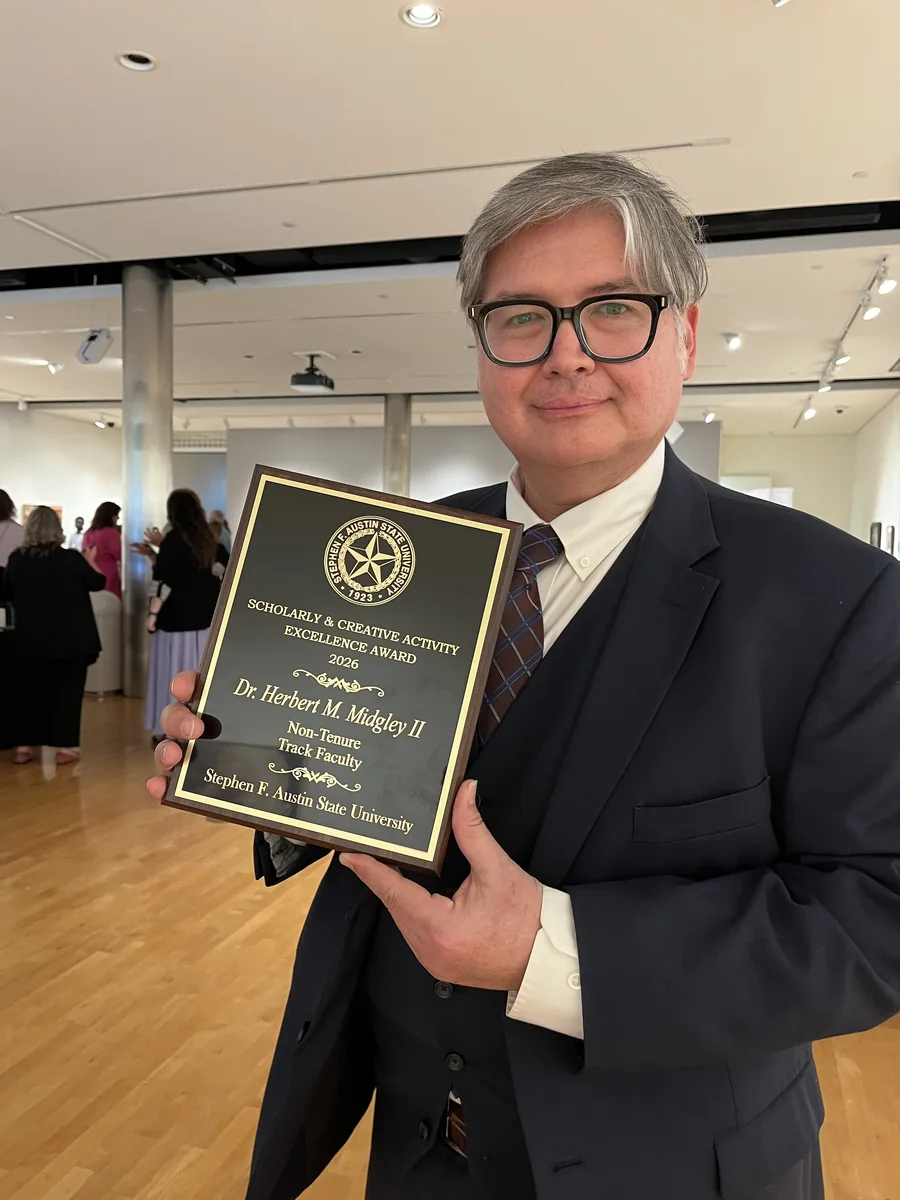 Herbert Midgley holding a university academic award