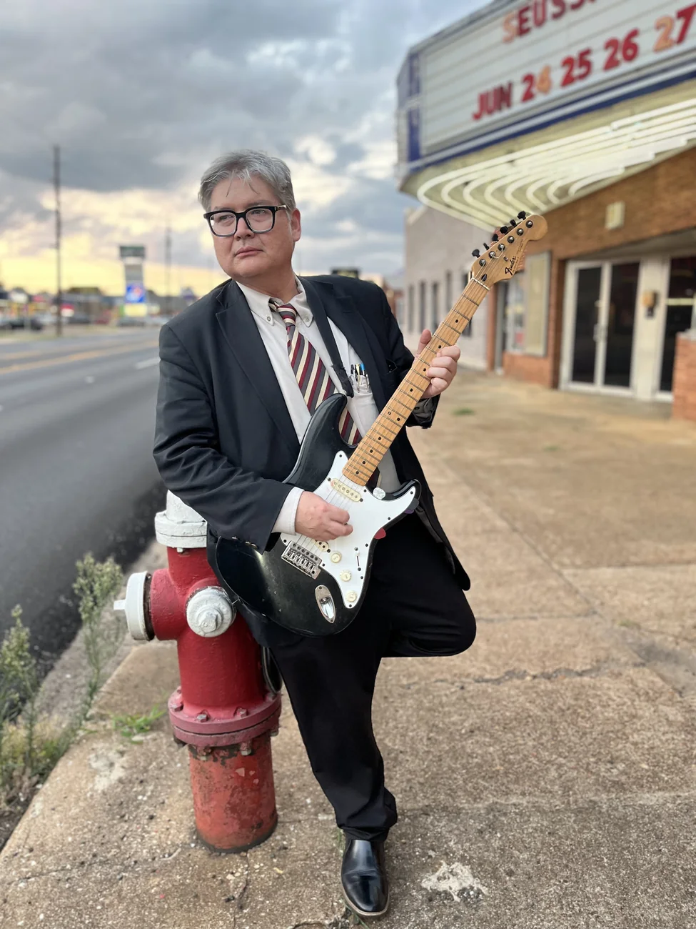 Herbert Midgley holding an electric guitar