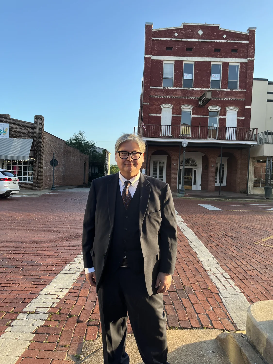 Herbert Midgley standing on a historic brick street in East Texas