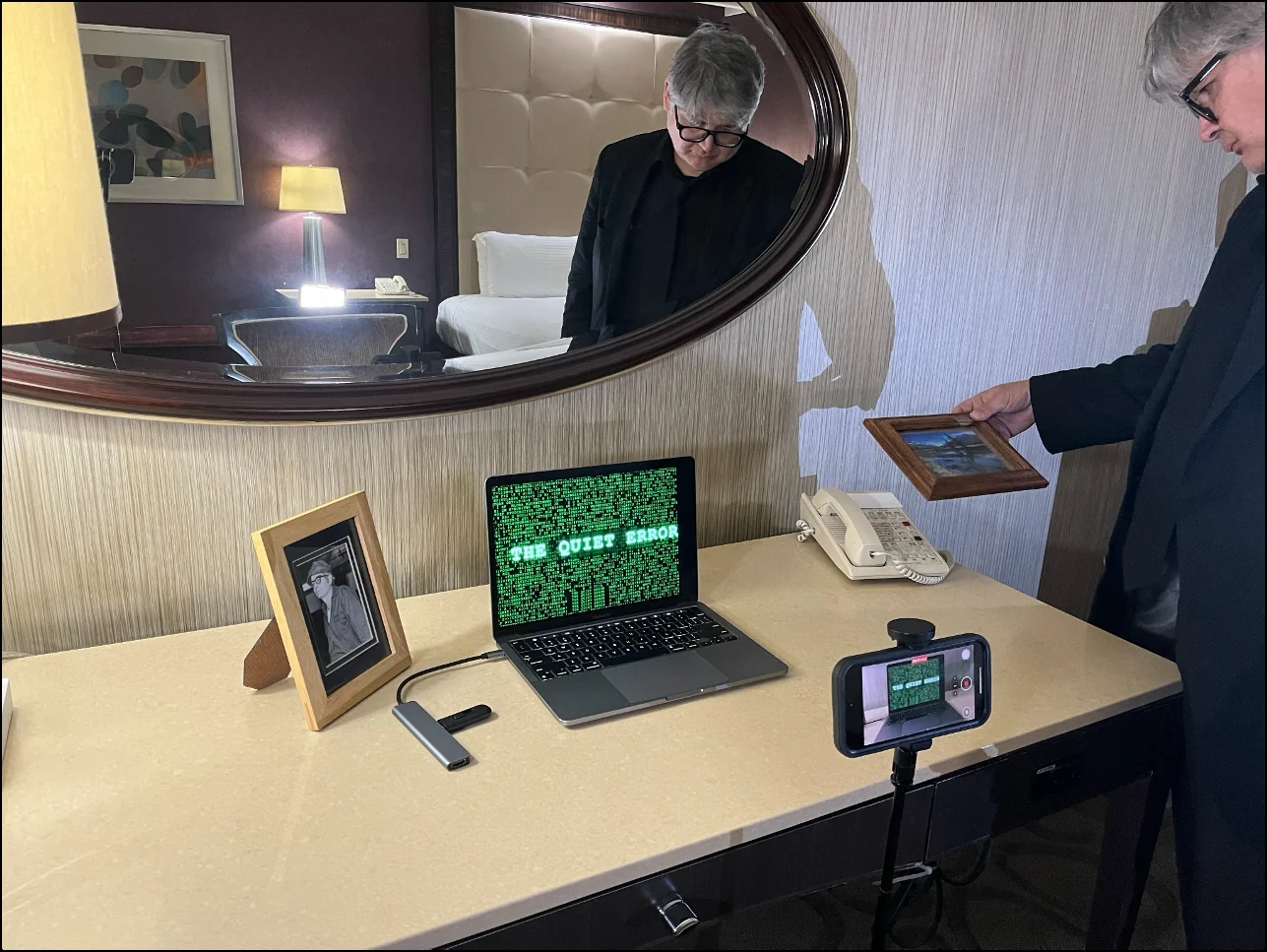 Production setup for The Quiet Error with a laptop, camera, and green code