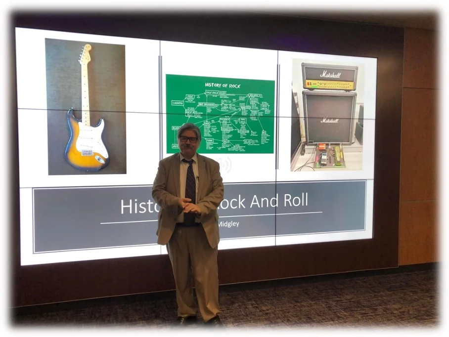 Herbert Midgley presenting a lecture on the history of rock and roll